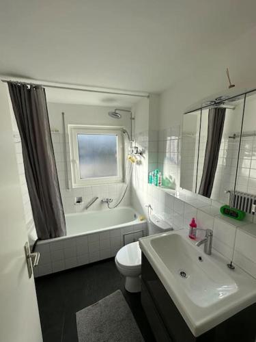 a bathroom with a toilet and a tub and a sink at Double Bed Apartment - Near Marienplatz in Stuttgart