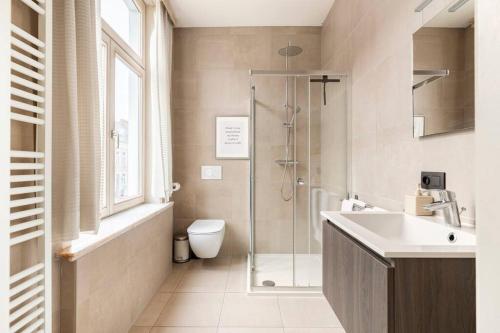 a bathroom with a shower and a sink and a toilet at Suite Stays Bruges in Bruges