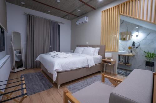 a bedroom with a large bed and a living room at THE ROOMS in Kato Loutraki