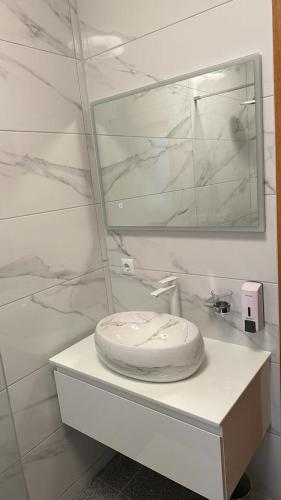 a white bathroom with a sink and a mirror at Villa Baldi -Apartmani Danny in Tar