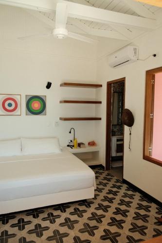 a white bedroom with a bed and a table at Seaflower Boutique lodge in Providencia