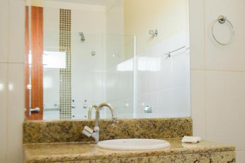 a bathroom with a sink and a shower at BOMBONATO HOTEL - Fácil Acesso ao Aeroporto e parque de Exposições ABCZ in Uberaba