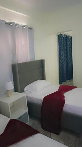 a bedroom with two beds and a window with a red pillow at Neo’s hotel in Santa Cruz de Barahona