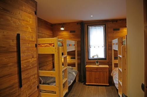 Cette chambre comprend plusieurs lits superposés et une fenêtre. dans l'établissement Chalet Shangrila, aux Angles