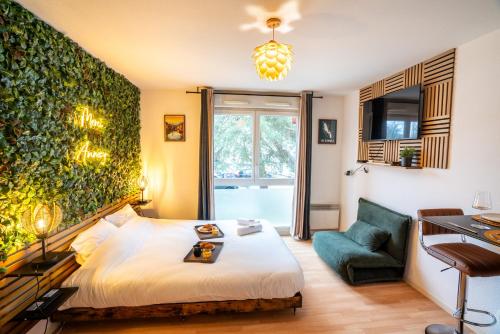 une chambre avec un lit et un mur végétal dans l'établissement Cabana & Merci Annecy - Parking et Proche du Lac, à Annecy