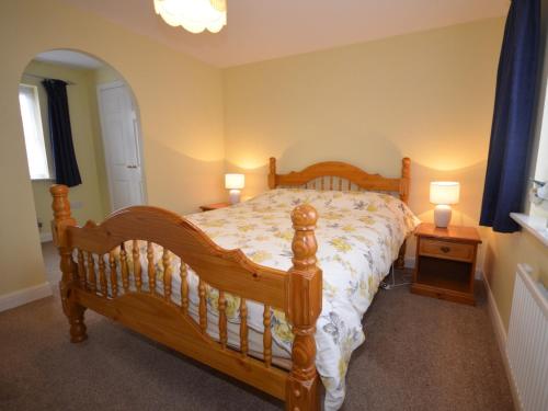 een slaapkamer met een houten bed en 2 lampen bij 3 bed in Minehead TRINI in Minehead