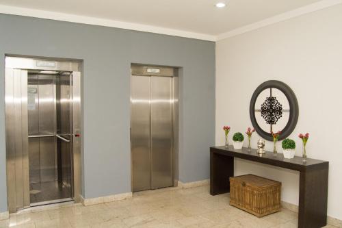 a hallway with a elevator and a mirror at BOMBONATO HOTEL - Fácil Acesso ao Aeroporto e parque de Exposições ABCZ in Uberaba