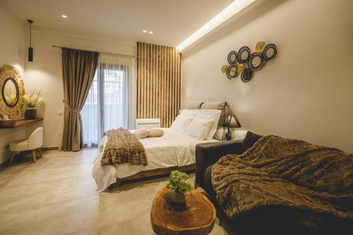 a bedroom with a bed and a couch and a table at Naias Nemeia Luxury Rooms in Neméa