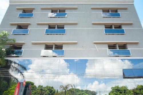 a building with a reflection of the sky in a window at BOMBONATO PALACE HOTEL in Uberaba