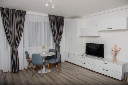 a living room with a table and a television at Maria's Premium Suite in Baia Mare