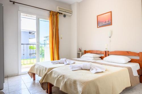 two beds in a room with a window at Sunrise2 in Paralia Katerinis