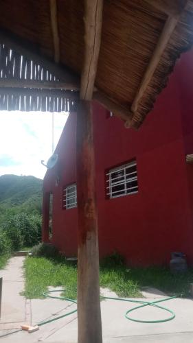 uma casa vermelha com uma parede vermelha e um edifício em La Morada em San Roque