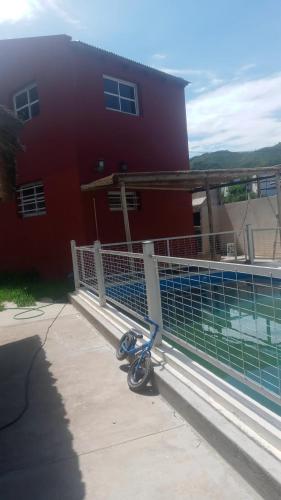 einem Roller, der vor einem roten Gebäude parkt in der Unterkunft La Morada in San Roque