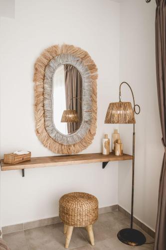 a mirror on a shelf with a chair and a lamp at Naias Nemeia Luxury Rooms in Neméa