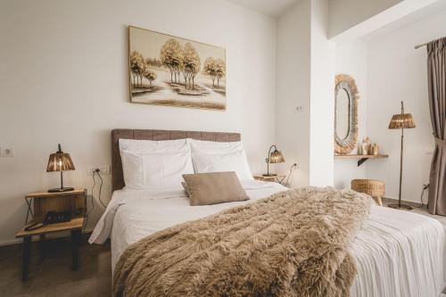 um quarto com uma cama grande e um cobertor em Naias Nemeia Luxury Rooms em Neméa