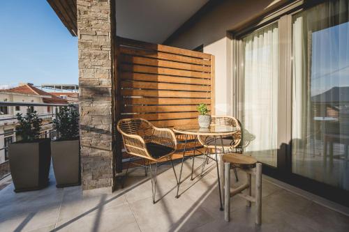 um pátio com uma mesa e cadeiras numa varanda em Naias Nemeia Luxury Rooms em Neméa