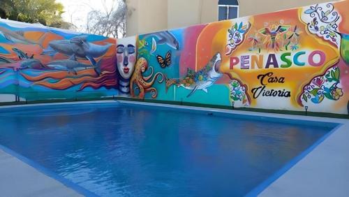 a swimming pool with a mural on the wall at Hotel Casa Victoria in Puerto Peñasco