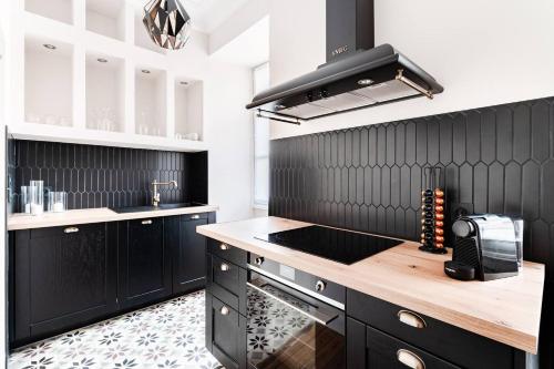 uma cozinha com armários pretos e uma bancada em Le 107Chinon em Chinon