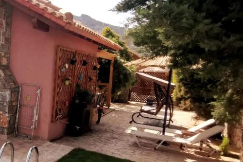 a house with a patio with chairs in front of it at Beautiful Villa with a private pool ! in Heraklion