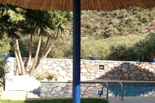 a stone wall with trees and a stone fence at Beautiful Villa with a private pool ! in Heraklion