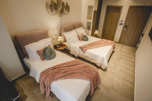 a bedroom with two beds with pillows on them at Naias Nemeia Luxury Rooms in Neméa