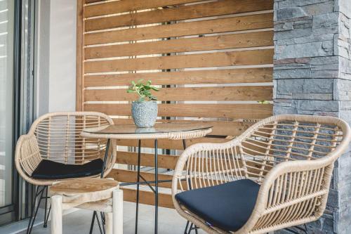 a patio with two chairs and a table with a plant at Naias Nemeia Luxury Rooms in Neméa