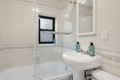 a white bathroom with a sink and a shower at Modern Luxe in Bay Ridge Your Brooklyn Hideaway in Brooklyn