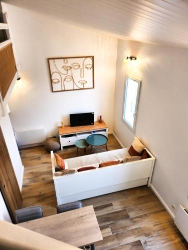 un salon avec un canapé et une table dans l'établissement A 150m du port, Le Baia, tout à pied, à Saint-Martin-de-Ré