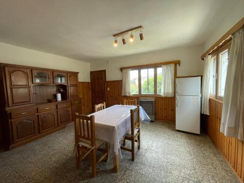 a kitchen with a white table and a refrigerator at Hermosa casa zona céntrica Bariloche in San Carlos de Bariloche