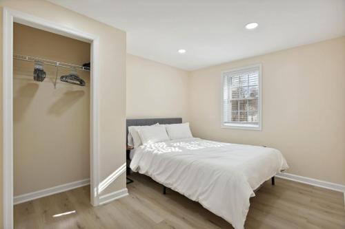 a white bedroom with a bed and a window at Luxury 3 BR Single Family Home - Half acre lot in Herndon