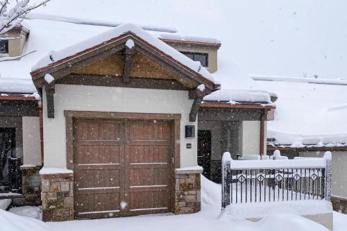 a house with a garage door covered in snow at The Village Ski In Ski Out in Beaver Creek