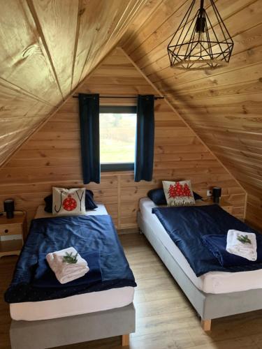 two beds in a room with a attic at sKLONowane domki pod Czarną Górą in Bystrzyca Kłodzka