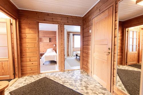 Habitación con paredes de madera y puertas con dormitorio. en Rukan Talvihovit, en Ruka