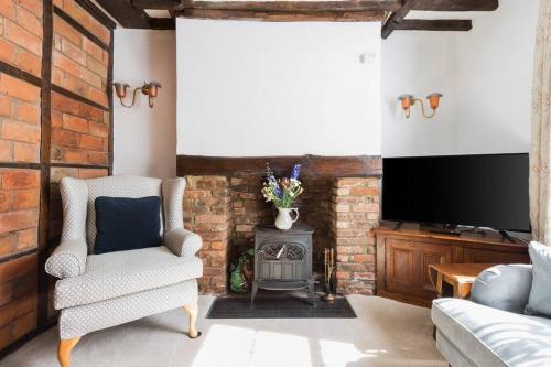 a living room with a chair and a television at Sarahs Cottage in Taunton
