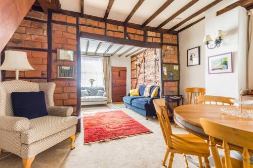 a living room with a table and a dining room at Sarahs Cottage in Taunton