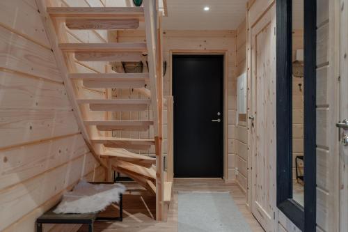 a staircase in a wooden house with a black door at Helt nytt exklusivt boende i Stöten in Sälen