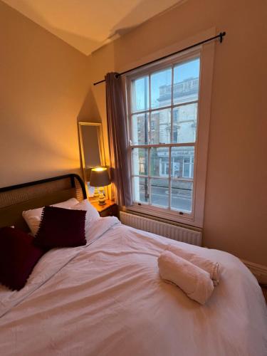 a bedroom with a white bed with a window at Apartament Kings Cross in London