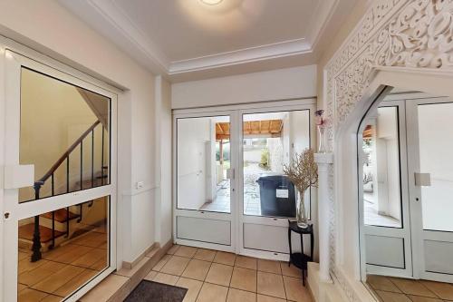 a hallway with sliding glass doors and a staircase at Cosy duplex aux portes de Paris in Maisons-Alfort
