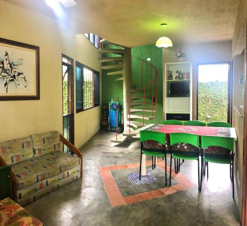 un soggiorno con tavolo verde e divano di Chalé Verde a Tamandaré