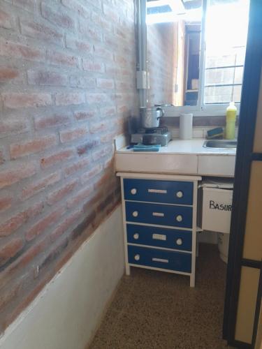 eine Küche mit Ziegelwand und Spüle in der Unterkunft Dormi familiar in Alta Gracia