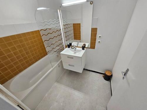 La salle de bains est pourvue d'une baignoire, d'un lavabo et d'une douche. dans l'établissement Très bel Appartement, 10 min gare, 20 min de Paris, à Garges-lès-Gonesse