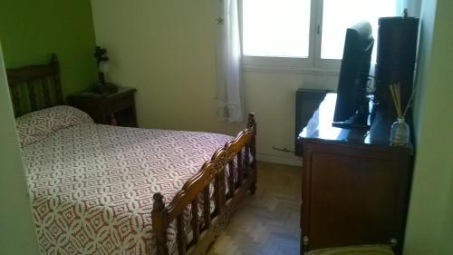 um quarto com uma cama e uma televisão numa cómoda em Habitación privada en Casa Musical I em Mar del Plata