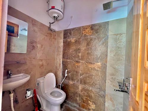 une salle de bains avec toilettes et lavabo dans l'établissement Flüstern Homestay, à Nagar