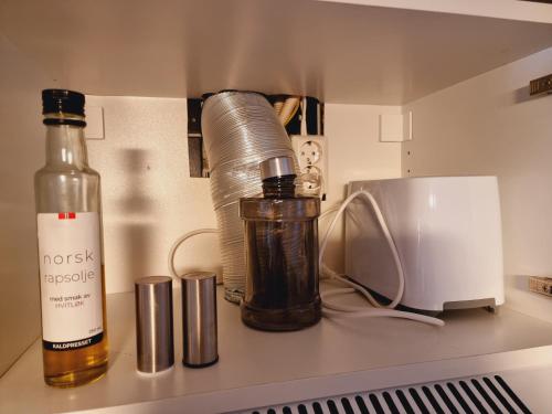 a kitchen counter with a bottle of alcohol and a blender at Kjellerleilighet egen inngang. in Stange
