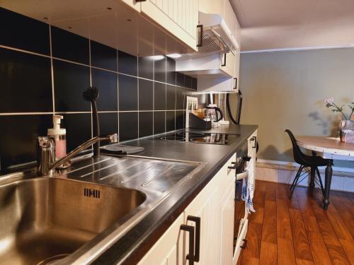 a kitchen with a stainless steel sink and a table at Kjellerleilighet egen inngang. in Stange