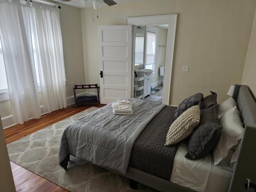 um quarto com uma cama grande e um espelho em Cozy Swamp Rabbit - Sans Souci Greenville Furman em Greenville