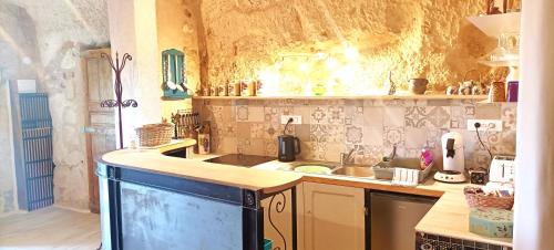 uma cozinha com um lavatório e uma bancada em Troglogîtes de la Tourette em Les Roches-lʼÉvêque
