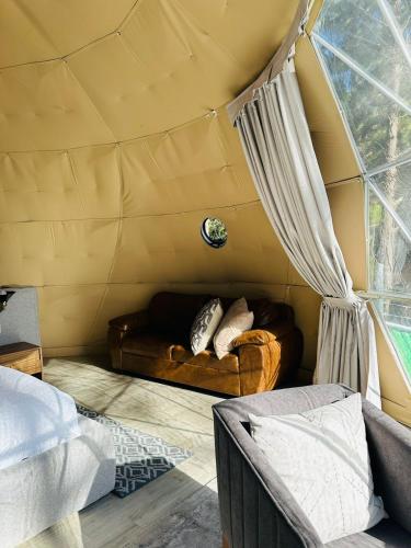a room with a bed and a couch in a tent at Tres Lunas Domo in Mazamitla