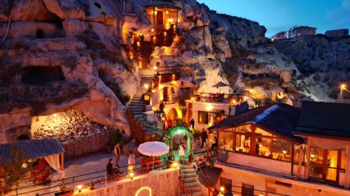 um grupo de edifícios numa montanha à noite em Cappadocia Nar Cave House & Swimming Pool em Nevşehir