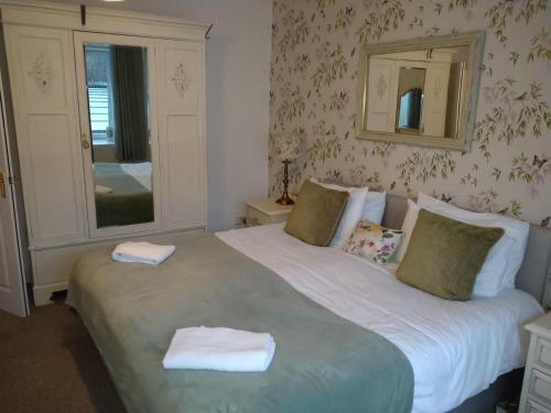 a bedroom with a large bed with two towels on it at 5 bedrooms sleeps 10-12 free wifi & parking garden in Lundin Links